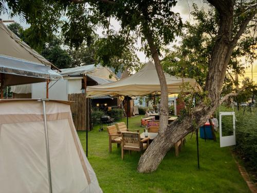 a tent and a table and chairs under a tree at With you camp in Ban Kham Kom