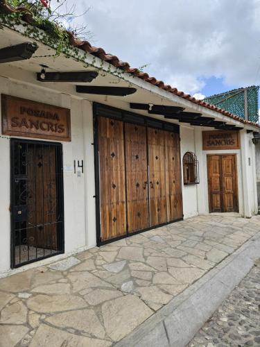 a building with wooden doors on the side of it at Posada Sancris in San Cristóbal de Las Casas