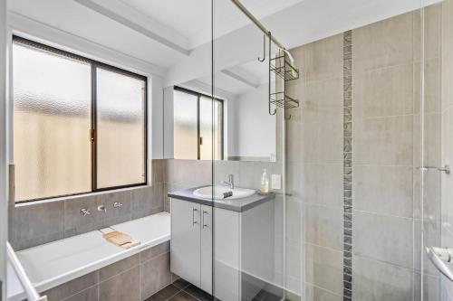 a bathroom with a tub and a sink and a shower at Cooinda Happy Place 3BR Home with Pool in Eaton