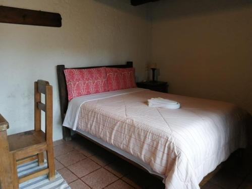 a bedroom with a large bed with a red headboard at Posada Sancris in San Cristóbal de Las Casas