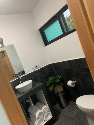 a bathroom with a sink and a toilet and a window at Casa Carolina Loft Aryaz in Tepoztlán