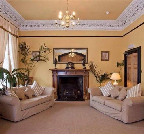 a living room with two couches and a fireplace at The Royal Hotel Tain in Tain