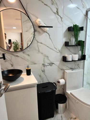 a bathroom with a sink and a mirror and a toilet at 22- APTO NOVO 7 min do Aeroporto de Guarulhos Garagem Coberta in Cumbica