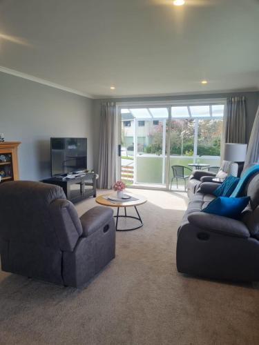 a living room with two couches and a table at Unit 46a in Timaru
