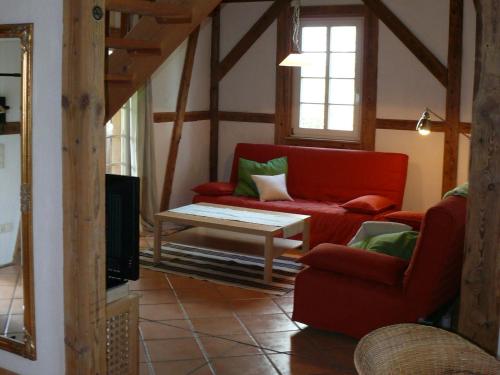 a living room with a red couch and a table at Alte Wassermühle in Salem