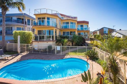 a house with a swimming pool in front of a house at Baywatch 3 in Merimbula