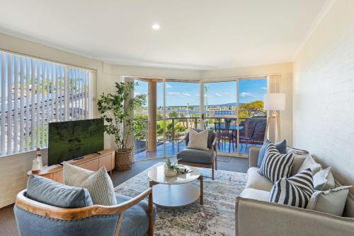 a living room with a couch and a tv at Baywatch 3 in Merimbula