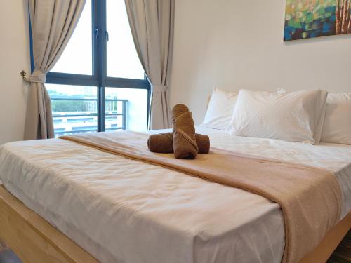 a teddy bear sitting on a bed with a window at Near Airport K Avenue Family Room in Donggongon