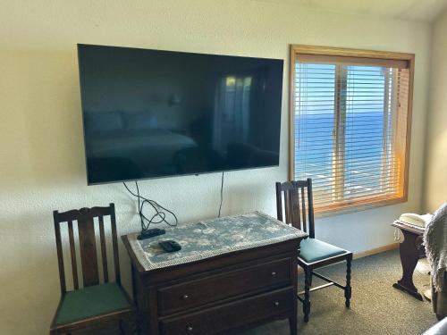 a living room with a tv and a table and chairs at Turtle Rocks Oceanfront Inn in Trinidad