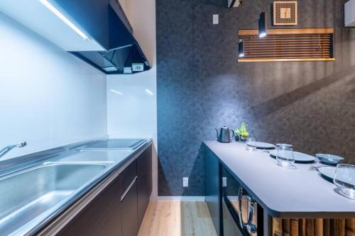 a kitchen with a sink and a counter top at Yume usjまで電車で1分 駐車場付きの日本の宿 寝室4つ お風呂 トイレ2つ 最大10名 in Osaka