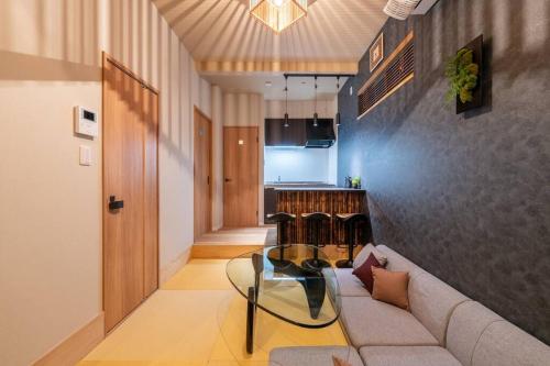 a living room with a couch and a glass table at Yume usjまで電車で1分 駐車場付きの日本の宿 寝室4つ お風呂 トイレ2つ 最大10名 in Osaka