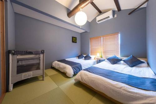 a bedroom with two beds and a tv in it at Yume usjまで電車で1分 駐車場付きの日本の宿 寝室4つ お風呂 トイレ2つ 最大10名 in Osaka