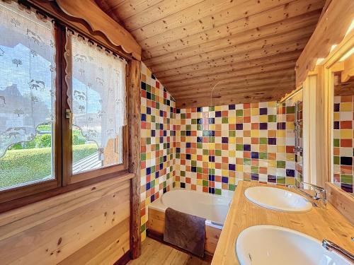 La salle de bains est pourvue d'un lavabo, d'une baignoire et d'une fenêtre. dans l'établissement Chalet 5 chambres près de Megève avec vue Mont Blanc - FR-1-560-148, à Demi-Quartier