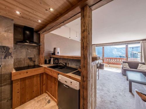 Il comprend une cuisine équipée d'une cuisinière. - un four supérieur à côté d'un salon dans l'établissement Centre station Courchevel 1850, 2 espaces, 4 à 6 personnes, skis aux pieds, wifi, parking - FR-1-631-216, à Courchevel