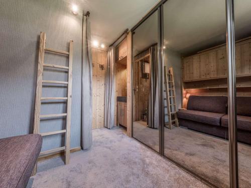 une chambre avec deux lits superposés et un miroir dans l'établissement Centre station Courchevel 1850, 2 espaces, 4 à 6 personnes, skis aux pieds, wifi, parking - FR-1-631-216, à Courchevel
