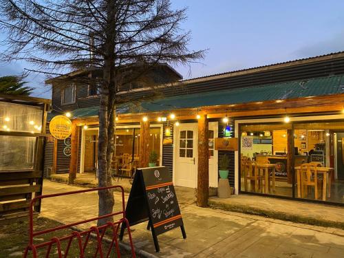 a restaurant with a sign in front of a building at Hostal Amerindia in Puerto Natales