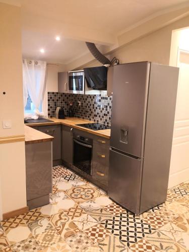 une cuisine avec un réfrigérateur en acier inoxydable dans l'établissement Résidence Hélène Boucher - Idéal entre Aéroport Paris Orly et Paris Centre 20mn, à Villeneuve-Saint-Georges