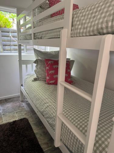 a bunk bed in a room with pillows at Water's Edge Holiday Home in Opua