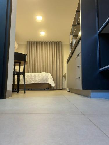 a bedroom with a bed and a chair in it at Prédio San Paolo - Bairro Santa Mônica próximo a UFU / Prefeitura / Center Shopping in Uberlândia