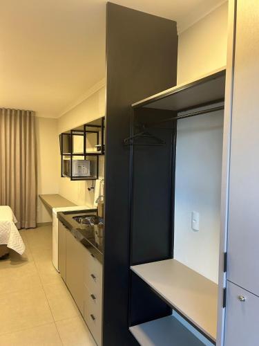a small kitchen with a black and white refrigerator at Prédio San Paolo - Bairro Santa Mônica próximo a UFU / Prefeitura / Center Shopping in Uberlândia
