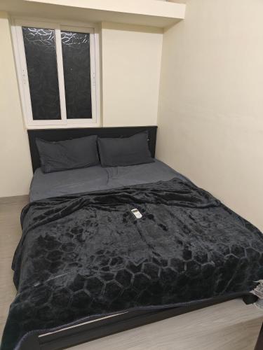 a bed with a black comforter in a bedroom at Elite Royal Heaven 3BHK in kāraikāl
