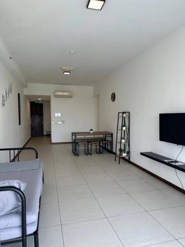 a room with two beds and a table and a tv at The Landmark Comfort Relax Spacious Sea View By IZ in Tanjong Tokong