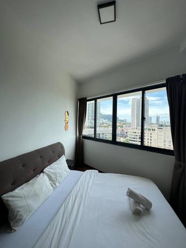 a bedroom with a white bed with a large window at The Landmark Comfort Relax Spacious Sea View By IZ in Tanjong Tokong