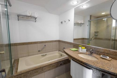 ein Badezimmer mit Badewanne und Waschbecken in der Unterkunft Belíssimo Duplex no Resort Costabella em Angra dos Reis in Angra dos Reis