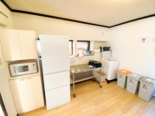 a kitchen with a refrigerator and a desk in a room at 最大5名様利用可 モダンでスタイリッシュなムーヴ戸田241 大型TV完備 wifiあり in Toda