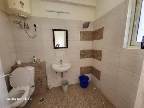 a bathroom with a toilet and a sink at BnBBuddy Modern Party Apt in Gurgaon in Gurgaon