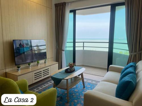 a living room with a couch and a tv at Mutiara Melaka Beach Resort by La CASA 2 in Tangga Batu