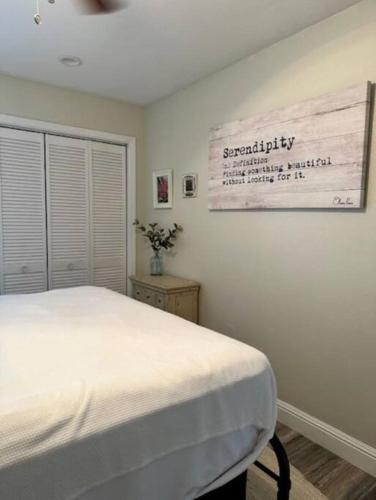 a bedroom with a bed and a sign on the wall at Valley Vibes and Beach Bliss Condo for Family Nomads in Waianae