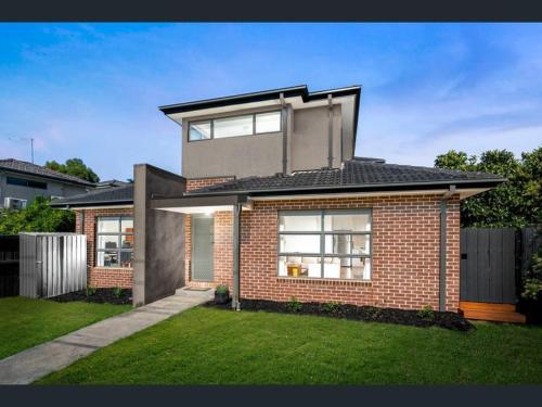 a red brick house with a large window at Melbourne home close to Airport & Train Station in Melbourne