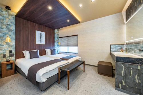 a bedroom with a large bed and a bathroom at JAPAVISTA Gekkou in Osaka