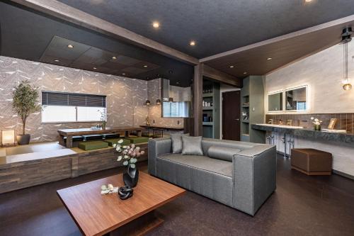 a living room with a couch and a table at JAPAVISTA Gekkou in Osaka