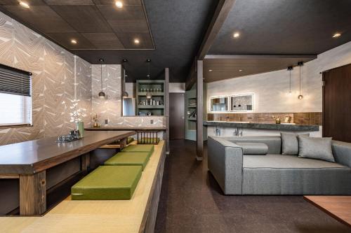 a living room with a couch and a bar at JAPAVISTA Gekkou in Osaka