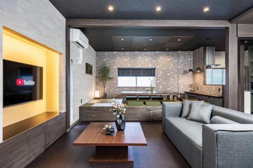 a living room with a couch and a table at JAPAVISTA Gekkou in Osaka