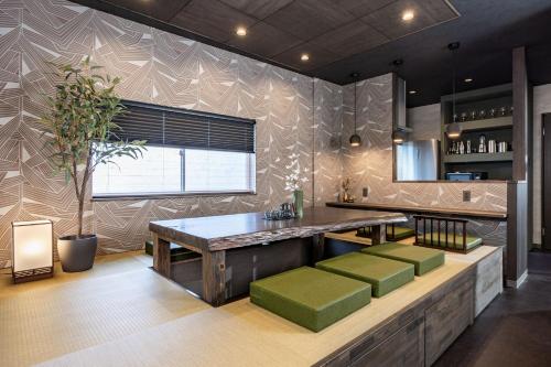 a kitchen with a table and green stools at JAPAVISTA Gekkou in Osaka