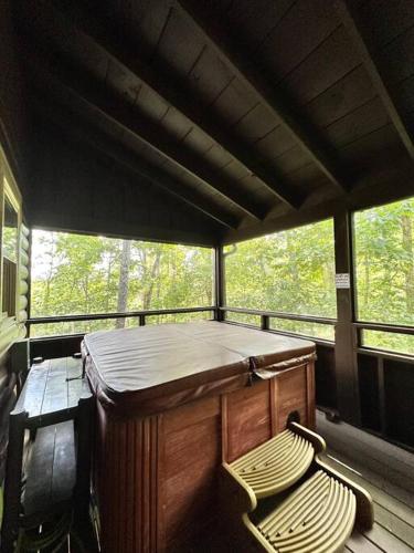 a bed and two chairs on a screened in porch at Moon Willow - one level cabin with 2 master suites in Walnut Grove
