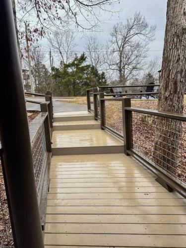 a wooden walkway with a fence and a tree at Moon Willow - one level cabin with 2 master suites in Walnut Grove