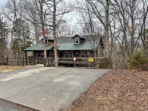 a house with a green roof in the woods at Moon Willow - one level cabin with 2 master suites in Walnut Grove