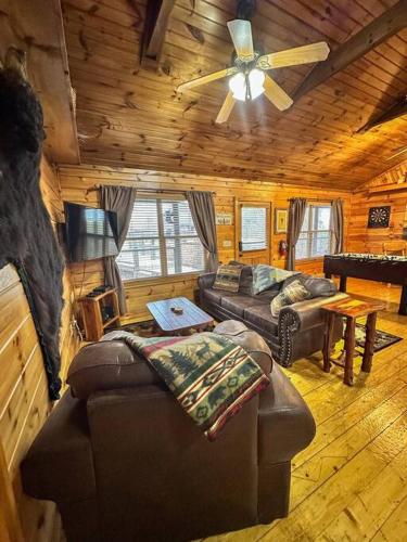 a living room with a couch and a ceiling fan at Moon Willow - one level cabin with 2 master suites in Walnut Grove