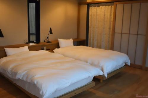 Una cama o camas en una habitación de INOKUCHITEI hiroshima