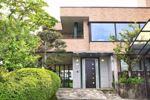 a brick house with a white door and windows at INOKUCHITEI hiroshima in Hiroshima