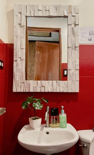 a bathroom with a white sink and a mirror at Hidden of Cailan Extension Transient House in El Nido
