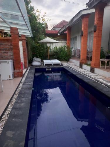 une piscine dans l'arrière-cour d'une maison dans l'établissement ATHAYA GUEST HOUSE canggu, à Kerobokan