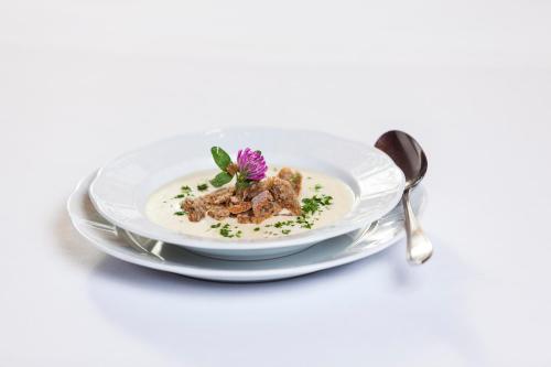 a plate of food with a purple flower on it at Hotel Jägerhof in San Leonardo in Passiria