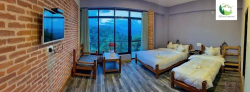 una camera con due letti e un muro di mattoni di Hotel Dhulikhel View Point a Dhulikhel