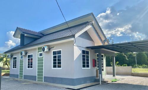 a small white and green house with a roof at Tulip's Homestay Kuala Berang-FREE WIFI in Kuala Berang