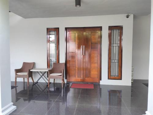 a room with a table and chairs and a wooden door at Aldeoz Group House Palembang in Palembang